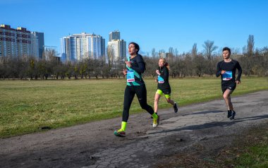 Bir grup koşucu dışarıda koşuyor. Kentsel alanda yarışan sportif insanlar, sağlıklı yaşam tarzı ve spor kavramları.
