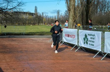 Genç dişiler maraton yarışında yarışıyorlar. Şehir parklarında ve caddelerde koşu yarışı.