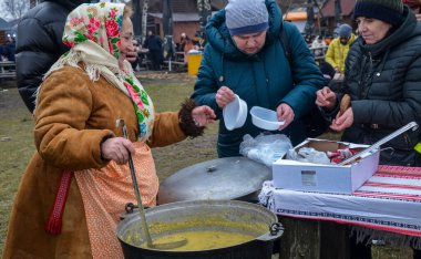 Kadın insanlara kulish ile davranıyor. Asırlık bir Ukrayna yemeği, çömlek, darı, salo, patates ve soğandan yapılmış Zaporizhian Kazakları tarafından popüler hale getirilmiş.
