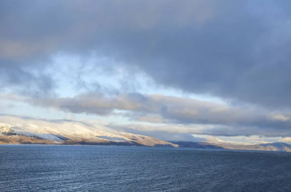 Спокойная Вода Озера Севан Подножия Заснеженных Горных Вершин Голубым Небом — стоковое фото