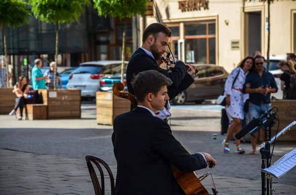 กดนตร างถนนสองคนคลาสส กเล นไวโอล นและเชลโลในถนนของเม Lviv เครน — ภาพถ่ายสต็อก