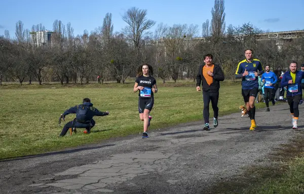 Bir grup koşucu dışarıda koşuyor. Kentsel alanda yarışan sportif insanlar, sağlıklı yaşam tarzı ve spor kavramları.