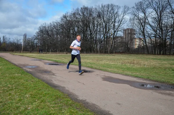 Şehir yolunda koşan sağlıklı bir koşucu. Sağlıklı kilo vermek ve kardiyo eğitimi almak için harika egzersizler.