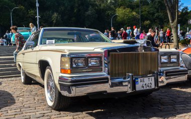 Beyaz klasik Amerikan yönetici arabası 2 kapılı beşinci nesil Cadillac DeVille 1984 'te retro araba sergisinde