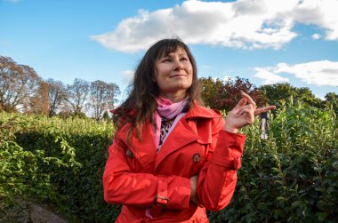 Çekici esmer hayalperest kız gülümsüyor ve anahtarı elinde tutuyor. Gayrimenkul alma kararının tadını çıkarıyor. Gelecek için fikirler ve kavramlar planlar