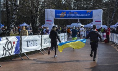 Koşucular Ukrayna bayrağını ellerinde tutarak, Rus askeri saldırılarına karşı Ukrayna 'yı desteklemek için bitiriyorlar.