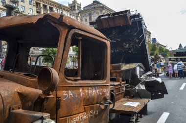 İnsanlar yanmış Rus çoklu fırlatma roket sistemi BM-21 Grad 'ın yanından geçiyor ve Ukrayna' nın başkenti Kyiv 'in merkezindeki Khreshchatyk Caddesi' nde fotoğraf çekiyor..