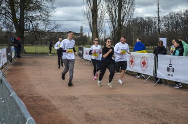 Bir şehir maratonu sırasında sokak yolunda koşan erkek ve kadın sporcular