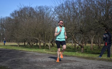 Koşucu maraton koşusu sırasında yolda koşuyor. Yüksek yoğunluklu koşular yapıyor.
