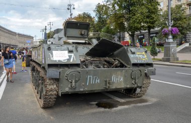 İnsanlar, Kyiv 'in merkezindeki Khreschatyk caddesinde, Ukrayna ordusu tarafından tahrip edilen Rus VDV birliğinin reostat aracının önünden geçtiler.