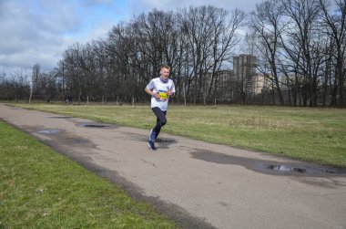 Koşucu yarışmasında koşan genç bir adamın görüntüsü. Koşu kıyafetli erkek sporcu dışarıda koşuyor..