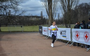 Genç dişiler maraton yarışında yarışıyorlar. Şehir parklarında ve caddelerde koşu yarışı.