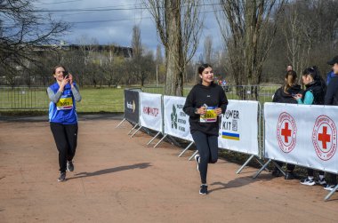 Genç dişiler maraton yarışında yarışıyorlar. Şehir parklarında ve caddelerde koşu yarışı.