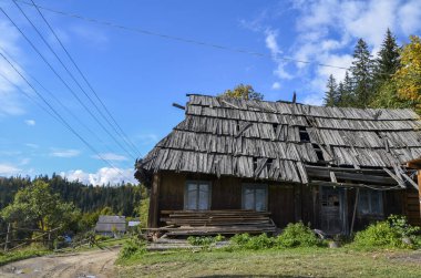 Dağlardaki köyde terk edilmiş eski ahşap evlerle dolu kırsal bir arazi. Karpatlar, Ukrayna