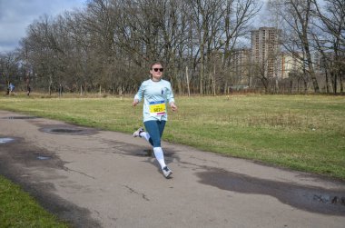Yaz parkı yolunda koşan genç atletik bayan koşucu. Sağlıklı kadın dışarıda koşuyor..