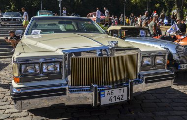 Beyaz klasik Amerikan yönetici arabası 2 kapılı beşinci nesil Cadillac DeVille 1984 'te retro araba sergisinde