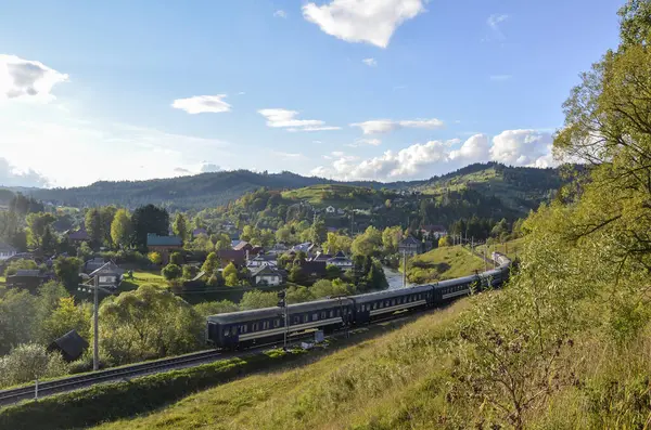 Güneşli bir sonbahar gününde, Vorokhta köyünün önünden tren geçen güzel bir dağ manzarası. Karpat Dağları, Ukrayna