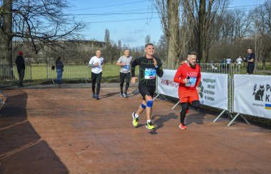 Koşucu maraton koşusu sırasında yolda koşuyor. Yüksek yoğunluklu koşular yapıyor.