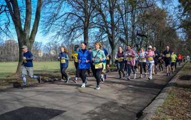 Bir grup koşucu dışarıda koşuyor. Kentsel alanda yarışan sportif insanlar, sağlıklı yaşam tarzı ve spor kavramları.