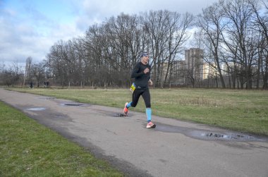 Spor giyim ve koşu ayakkabıları olan bir koşucu. Şehir sokaklarında maraton yaparken. Fitness ve sağlıklı yaşam tarzı konsepti 