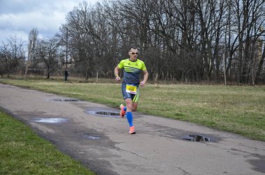 Spor giyim ve koşu ayakkabıları olan bir koşucu. Şehir sokaklarında maraton yaparken. Fitness ve sağlıklı yaşam tarzı konsepti 
