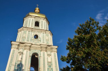 Aziz Sophia Katedrali 'nin çan kulesi mavi gökyüzünün arka planında altın bir kubbe parıltısıyla donatılmış sofistike desenlerle süslenmiş. Kyiv, Ukrayna