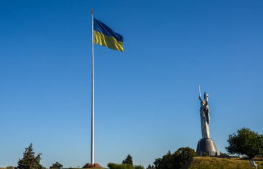 2. Dünya Savaşı 'na adanmış müze kompleksinde Anavatan' ın heykelinin yanında dalgalanan Ukrayna bayrağıyla bayrak direği. Kyiv, Ukrayna