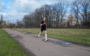 Şehirde koşan bir grup aktif insan. Takım koşusu maratonu. Sağlıklı çalıştırıcı kavramı