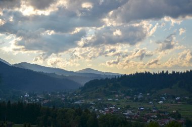 Günbatımı manzarası vadide köy evleri ve arka planda dağ sırtı. Karpat Dağları, Ukrayna