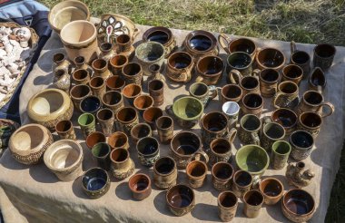 Halk sanatları pazarında seramik çömlek koleksiyonu. Çömlek, her biri karmaşık tasarım ve desenlere sahip çeşitli kap, kase ve kupa şekillerinden oluşur.