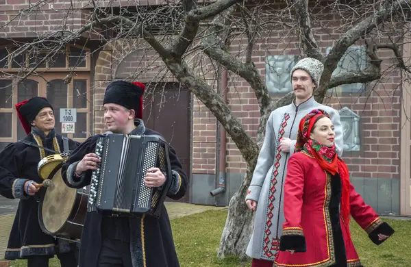 Geleneksel Ukrayna kostümü giyen folklor sanatçıları Shrovetide kutlamaları sırasında konuşuyorlar