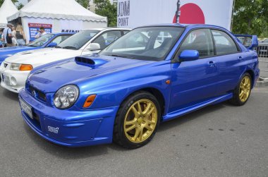 Mavi araba Subaru Impreza WRX STI 2002, Japon otomobil üreticisi Fuji Heavy Industries Subaru tarafından üretilen yüksek performanslı bir modeldir.