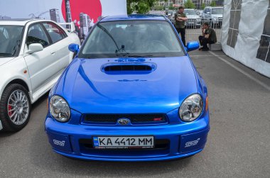 Mavi araba Subaru Impreza WRX STI 2002, Japon otomobil üreticisi Fuji Heavy Industries Subaru tarafından üretilen yüksek performanslı bir modeldir.