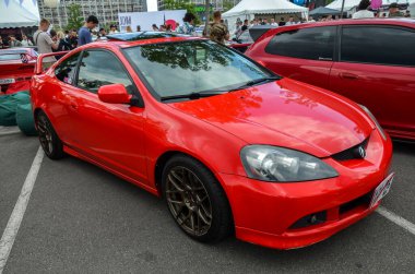 Kırmızı Acura RSX - otomobil festivali Kyiv Otomobil Festivali 'nde sunulan Honda Integra spor arabasının manevra önçekişli Amerikan alternatifi 