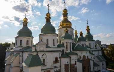 Aziz Sophia Katedrali 'nin haçları olan yeşil ve altın kubbeler açık mavi gökyüzüne karşı gün ışığı altında parıldıyor. Kyiv, Ukrayna