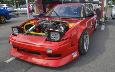 1990 Nissan 200SX S13, bugün bile araba meraklılarının kalbinde özel bir yere sahip uzun, süpürme çizgileri ve ön far ile kırmızı spor bir coupe 'dir.