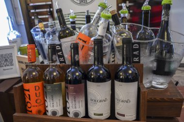 Şarap kültür festivalinde şarap tatma etkinliği sırasında ahşap bir kutuda ve buz kovasında çeşitli şarap şişeleri koleksiyonu.