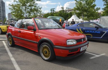 Kırmızı Volkswagen Golf 3. Nesil Cabrio (Tip 1E) şık ve çok yönlü üstü açık vitrinler yuvarlak farlı parlak bir tasarım ve tırmıklanmış ön cam.