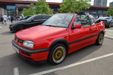 Kırmızı Volkswagen Golf 3. Nesil Cabrio (Tip 1E) şık ve çok yönlü üstü açık vitrinler yuvarlak farlı parlak bir tasarım ve tırmıklanmış ön cam.