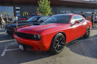 Kırmızı Dodge Challenger 3. Gen LA / LC facelift, klasik Amerikan stiliyle çağdaş performansı birleştiren modern bir kaslı arabadır. 
