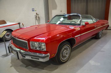 Beşinci neslin üstü açık kırmızı Chevrolet Impala 'sı tam bir klasik Amerikan arabasıdır. Geniş boyutu ile bilinen bu alanda 130 cm 'lik bir tekerlek mesafesi vardır.