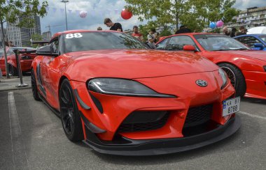 2020 model kırmızı Toyota Supra, BMW ile birlikte geliştirilmiş, turbo şarjlı güçlü bir motoru, çevik ve parlak aerodinamik çizgileri olan modern bir spor arabadır.