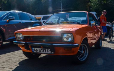 Turuncu 1978 Isuzu Gemini klasik bir araba olarak öne çıkıyor ve pratik ve eşsiz tasarım ile tanımlanan dönemin özünü yakalıyor.