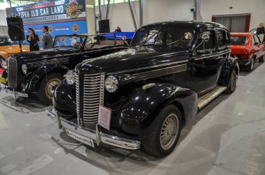 Zarif siyah 1936 Buick Special, 1930 'ların sofistike ve yenilikçiliğini temsil eden bir otomotiv ikonu ve geçmiş zamanın cazibesini ve lüksünü somutlaştırıyor.