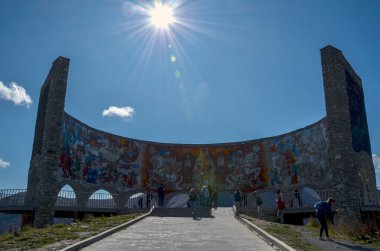 Çarpıcı bir arkadaşlık kemeri parlak güneşin altında, canlı mozaikler ve keşif yapan ziyaretçilerle dimdik ayakta duruyor. Sahne kültür, tarih ve turizmi yakalıyor 