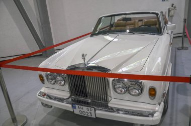 En çok üretilen üstü açık arabalardan biri, lüks beyaz Rolls-Royce Corniche, Rolls-Royce markasının mirasını ve prestijini somutlaştıran bir klasik.