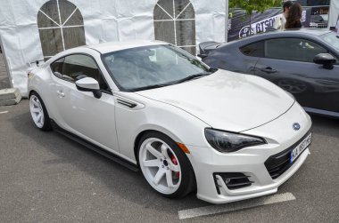 Beyaz spor araba Subaru BRZ bir açık hava otomotiv etkinliğinde sergileniyor. 