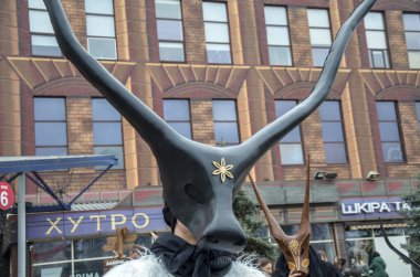 Fantastical creatures in elaborate animal masks with long antlers reflecting cultural traditions during Shrovetide celebration clipart