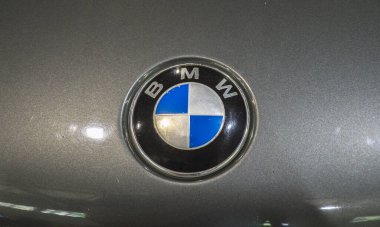 Bir arabanın kaputundaki ikonik BMW logosunun ayrıntılı görüntüsü, lüksü, performansı ve klasik tasarımı sembolize ediyor. Otomotiv meraklıları ve markalaşma kavramları için ideal