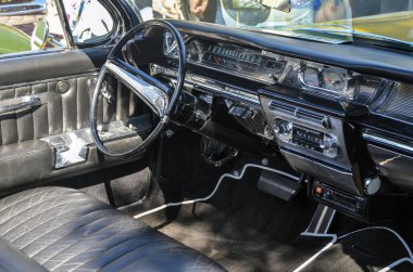 Antika tam boy limuzin 1962 Buick Electra 'nın içinde klasik bir gösterge paneli, cilalı detaylar ve zarif deri koltuklar sergileniyor.